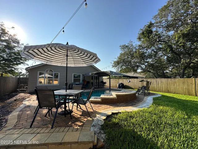 a view of a patio with table and chairs under an umbrella
