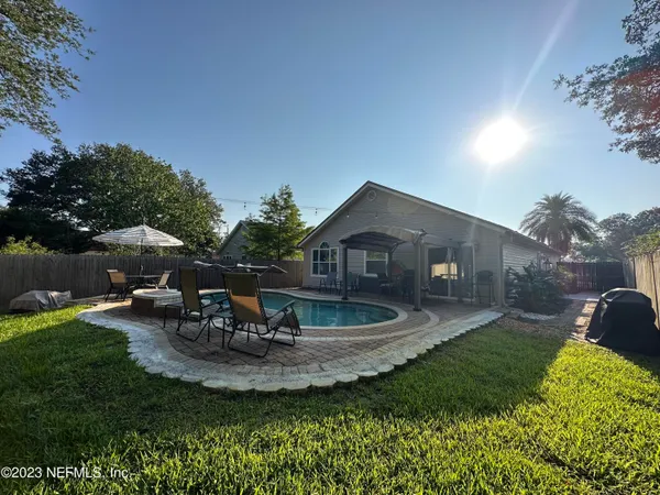 a view of a house with backyard sitting area and garden