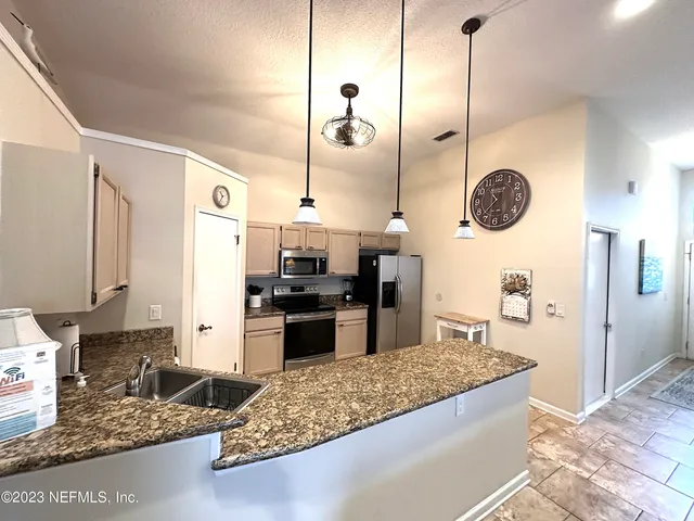 a large kitchen with stainless steel appliances kitchen island granite countertop a stove a sink and a granite counter tops