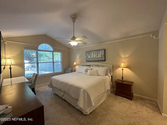 a spacious bedroom with a bed and a window