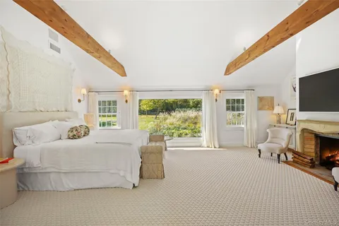 a spacious bedroom with a bed and a flat screen tv