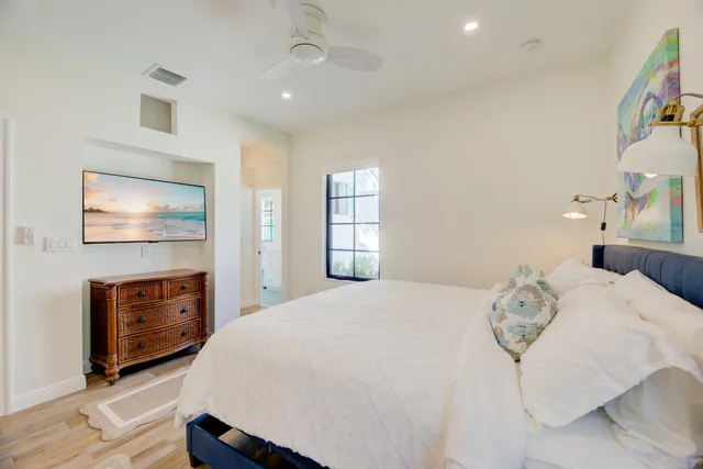 a bedroom with a bed and dresser with mirror