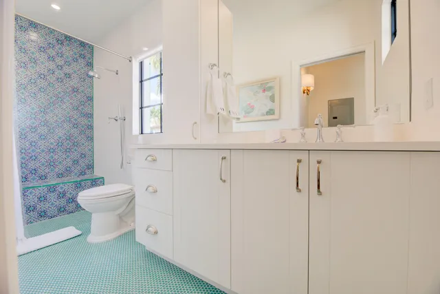 a bathroom with a toilet a sink a mirror and a shower