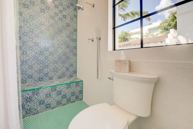 a white toilet sitting next to a shower