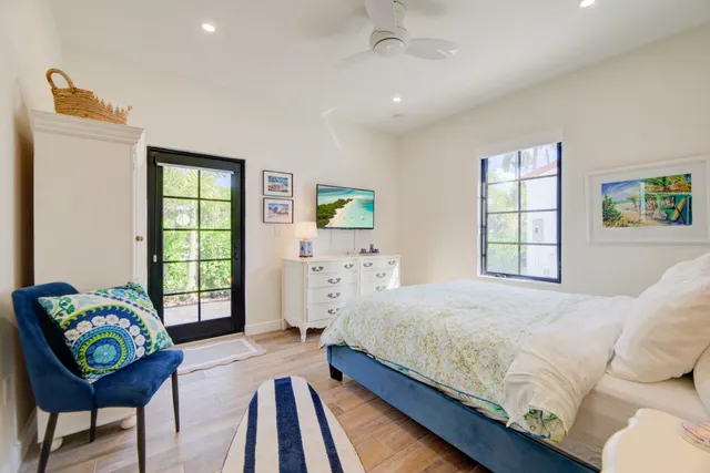 a bedroom with a bed mirror and a window