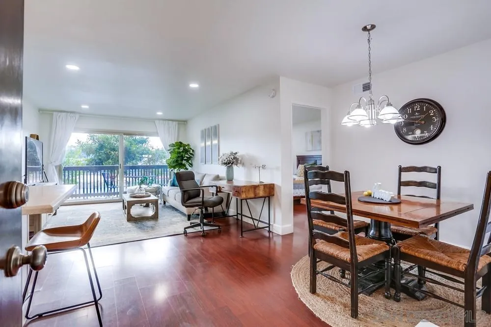 6314 Friars Road, Unit 116 San Diego, CA 92108 - Photo 1 of 36 a view of a dining room and livingroom with furniture wooden floor a rug a fireplace and a chandelier