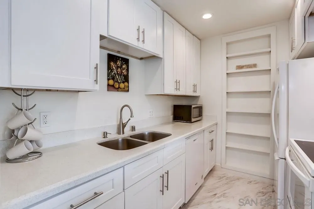 6314 Friars Road, Unit 116 San Diego, CA 92108 - Photo 11 of 36 a kitchen with white cabinets and a sink