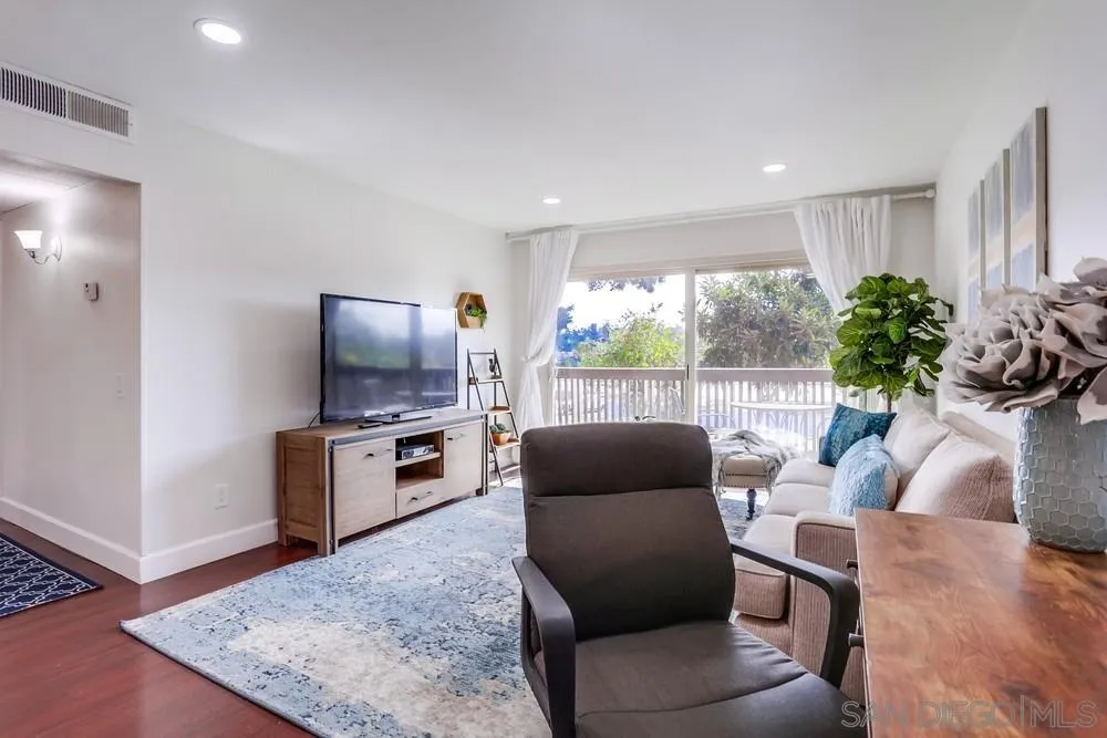 6314 Friars Road, Unit 116 San Diego, CA 92108 - Photo 6 of 36 a living room with furniture a large window and a flat screen tv