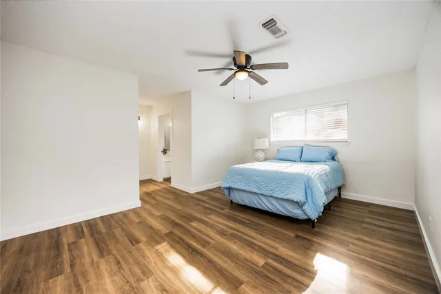 a bedroom with a bed and wooden floor