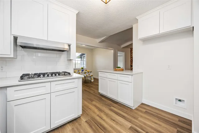 a kitchen with white cabinets and white appliances