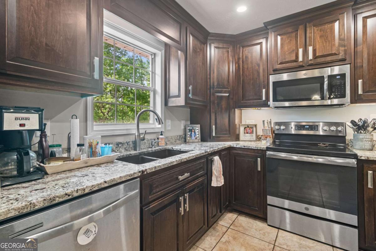 513 South Red Rock Road Toccoa, GA 30577 - Photo 18 of 47 a kitchen with granite countertop a sink stainless steel appliances and a window