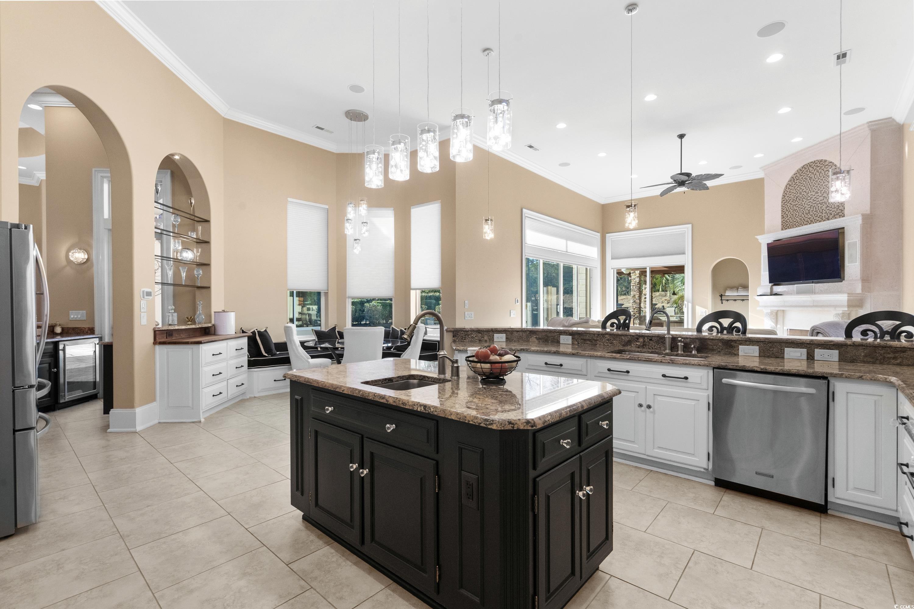 9237 Bellasera Circle Myrtle Beach, SC 29579 - Photo 11 of 34 Kitchen featuring stainless steel appliances, ceiling fan, light tile patterned floors, dark cabinets, and crown molding