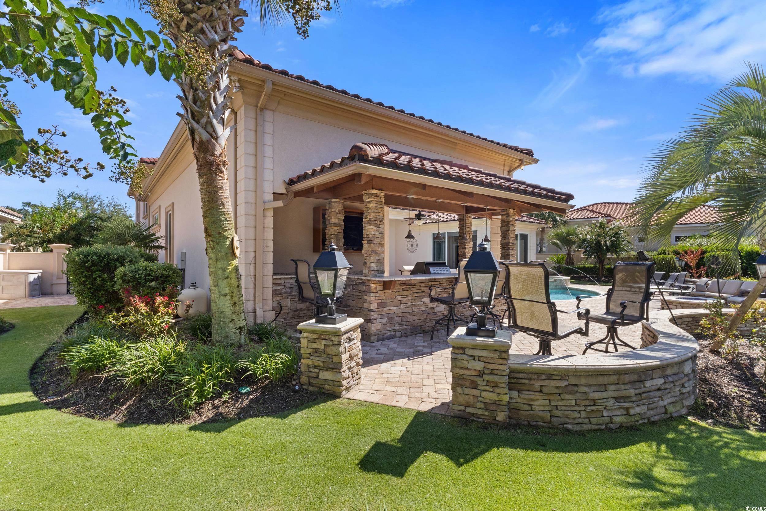 9237 Bellasera Circle Myrtle Beach, SC 29579 - Photo 28 of 34 Back of house featuring a patio, stucco siding, a tile roof, stone siding, and a lawn