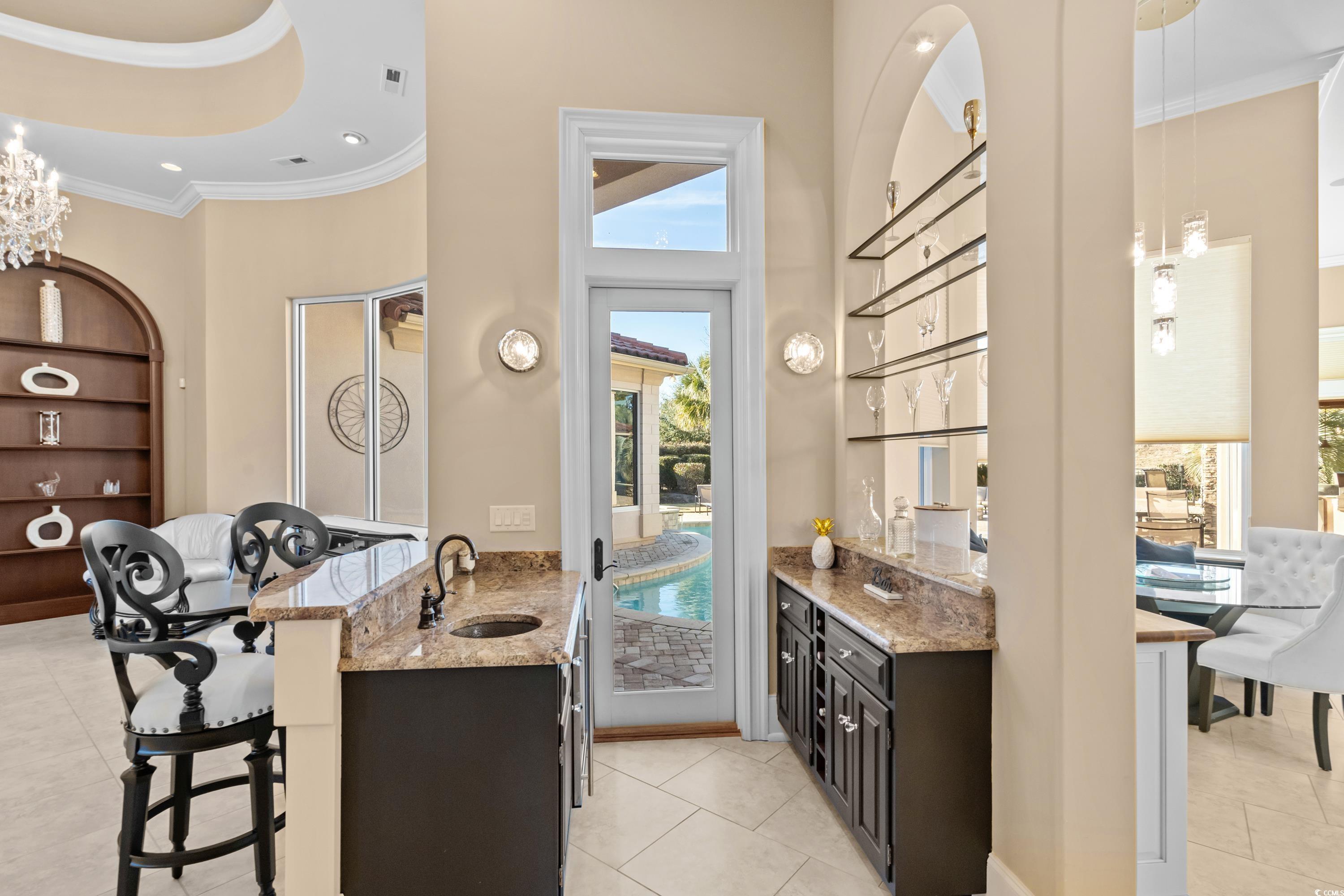 9237 Bellasera Circle Myrtle Beach, SC 29579 - Photo 10 of 34 Bar area with a towering ceiling, ornamental molding, light tile patterned flooring, recessed lighting, and a chandelier