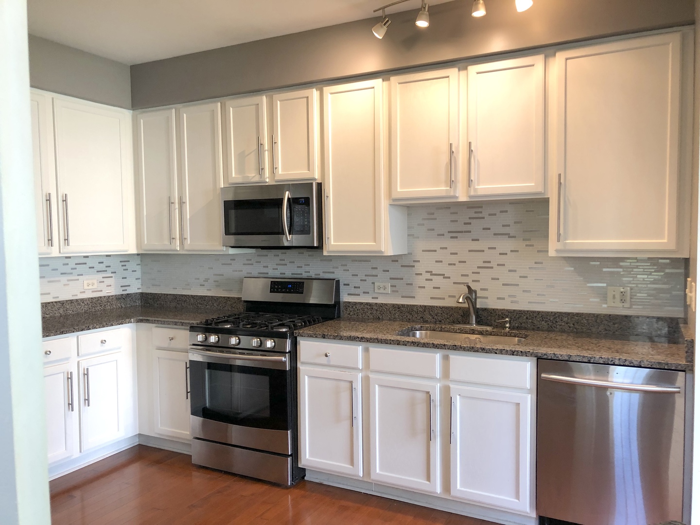 2330 Sheehan Drive Naperville, IL 60564 - Photo 9 of 18 a kitchen with granite countertop white cabinets and black stainless steel appliances