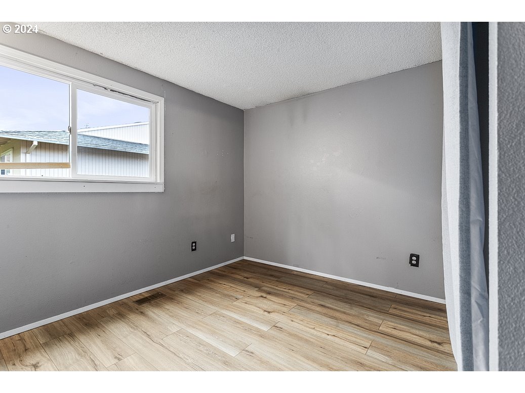 2772 Southwest 18th Place Gresham, OR 97080 - Photo 13 of 16 a view of empty room with window and wooden floor