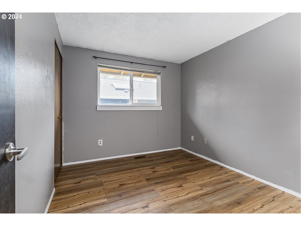 2772 Southwest 18th Place Gresham, OR 97080 - Photo 14 of 16 a view of an empty room with wooden floor and a window