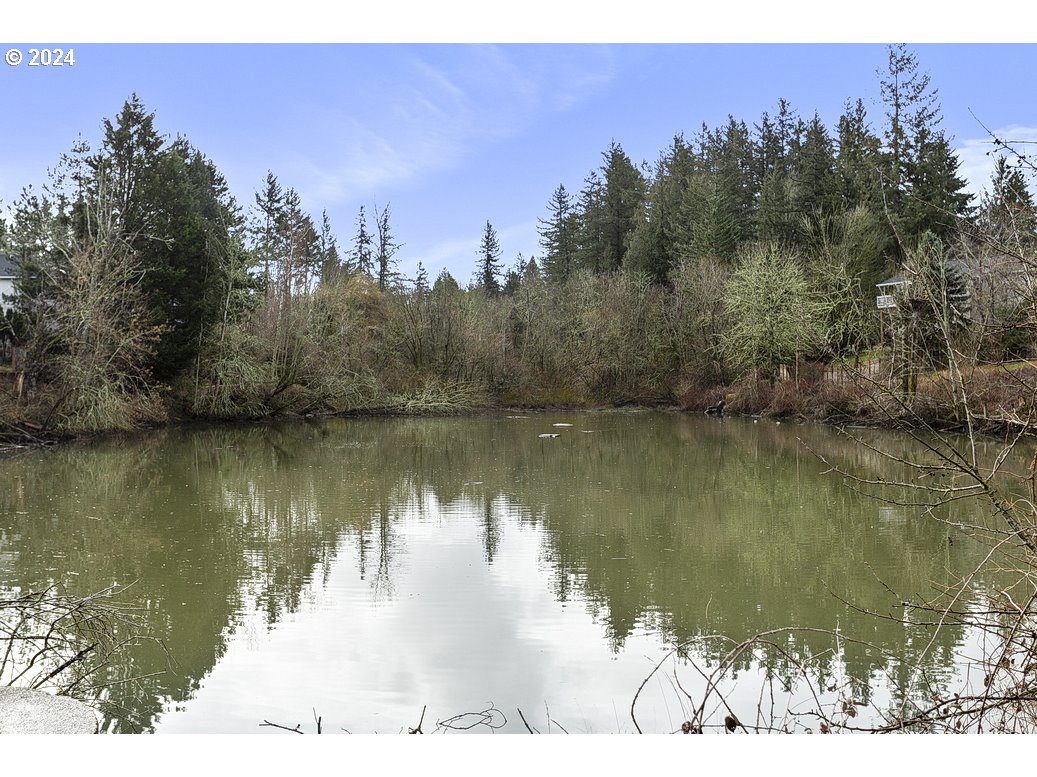 2772 Southwest 18th Place Gresham, OR 97080 - Photo 16 of 16 a view of a lake with a yard and trees in the background