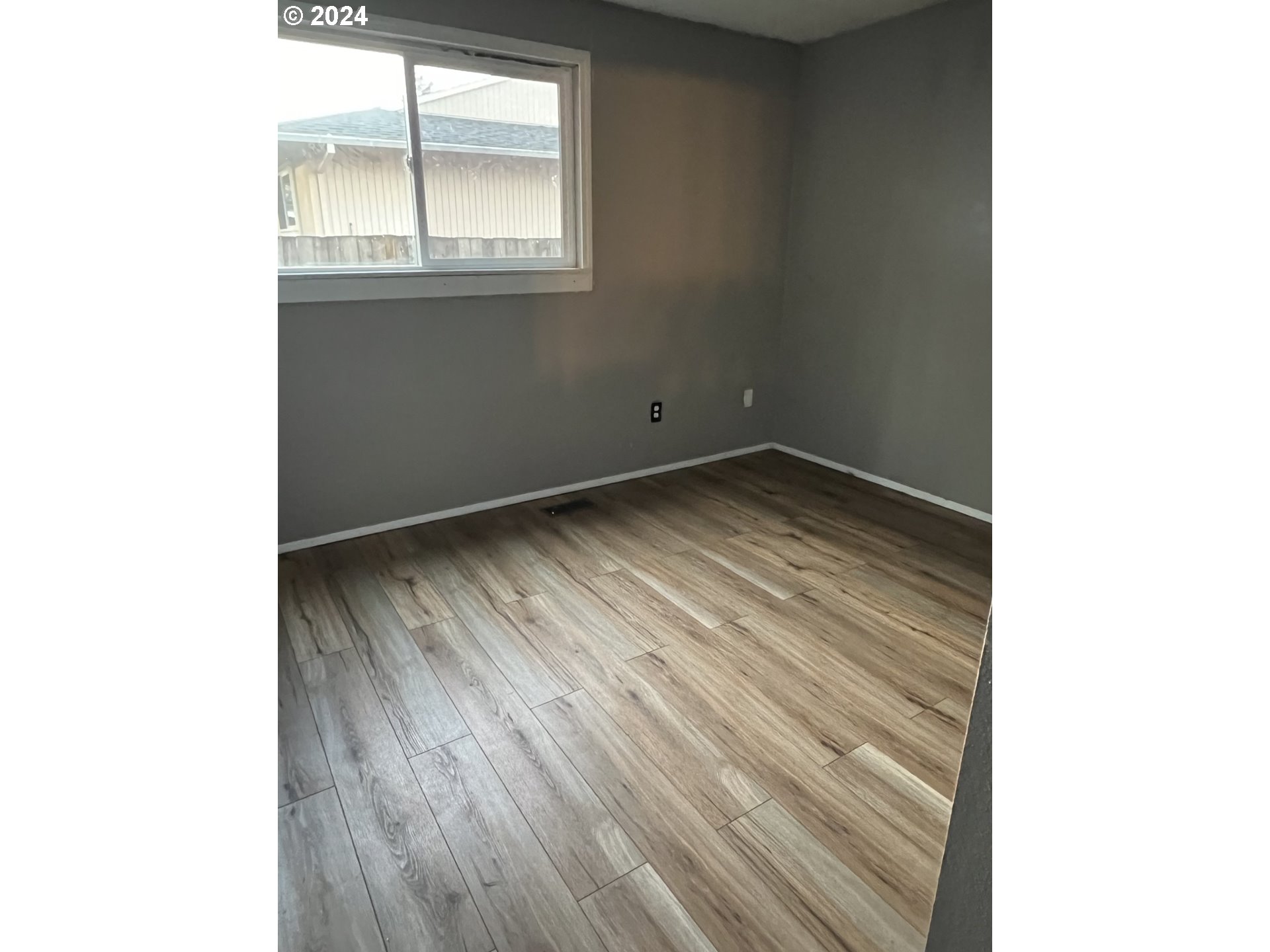 2772 Southwest 18th Place Gresham, OR 97080 - Photo 6 of 16 a view of an empty room with wooden floor and a window
