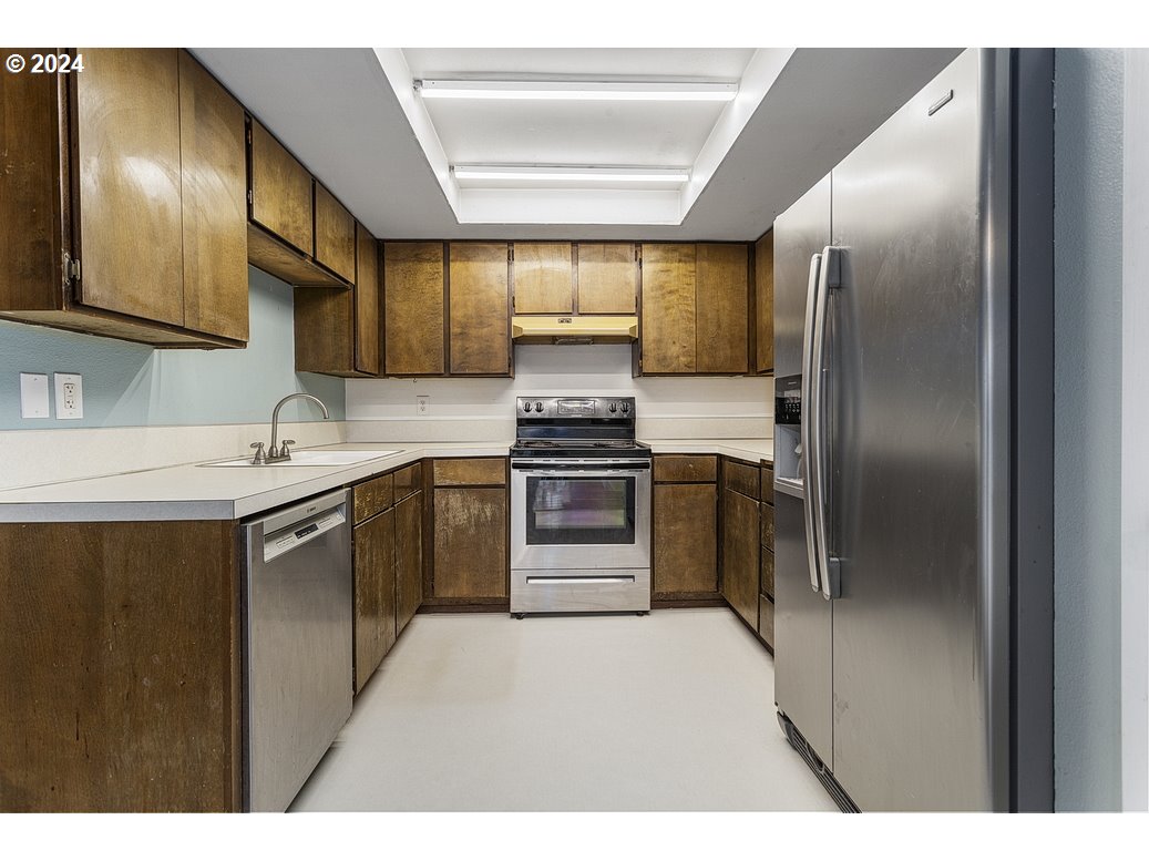 2772 Southwest 18th Place Gresham, OR 97080 - Photo 8 of 16 a kitchen with kitchen island a sink stove and refrigerator