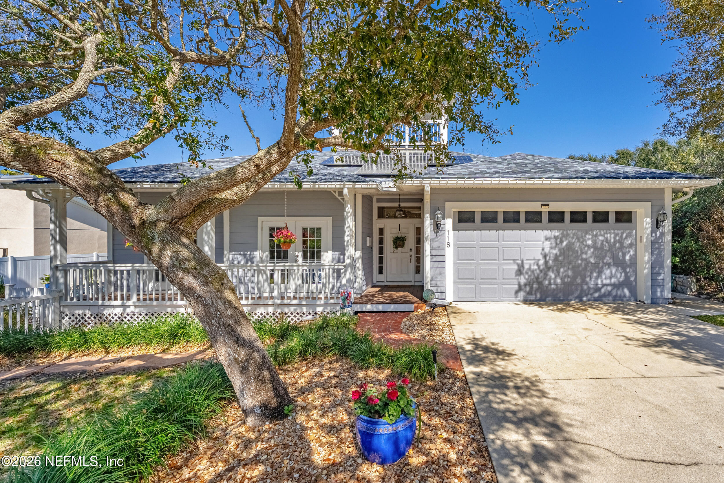a front view of a house with a yard and potted plants