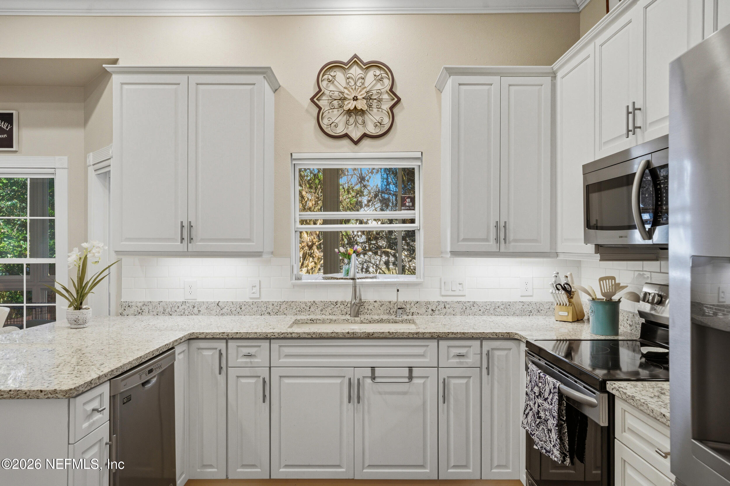118 3rd Street St. Augustine, FL 32084 - Photo 21 of 77 a kitchen with granite countertop white cabinets and stainless steel appliances