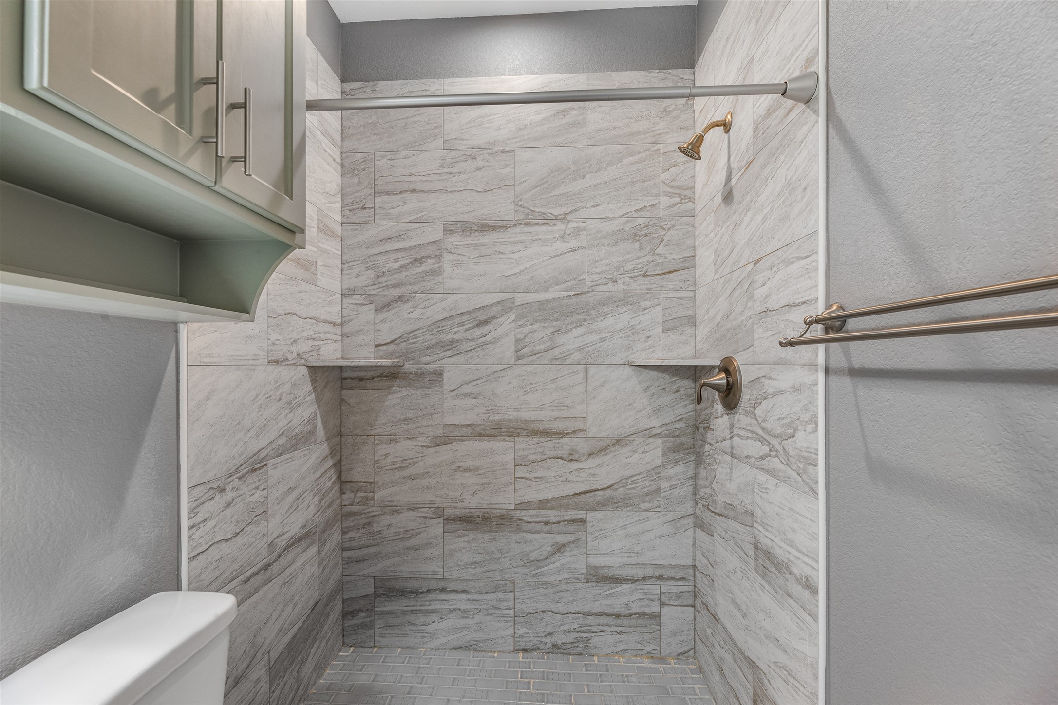 6501 Stratton Street Houston, TX 77023 - Photo 18 of 46 Spa-inspired walk-in shower with floor-to-ceiling marble-look tile.