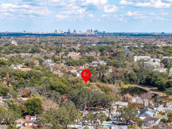 an aerial view of a houses with city and green space