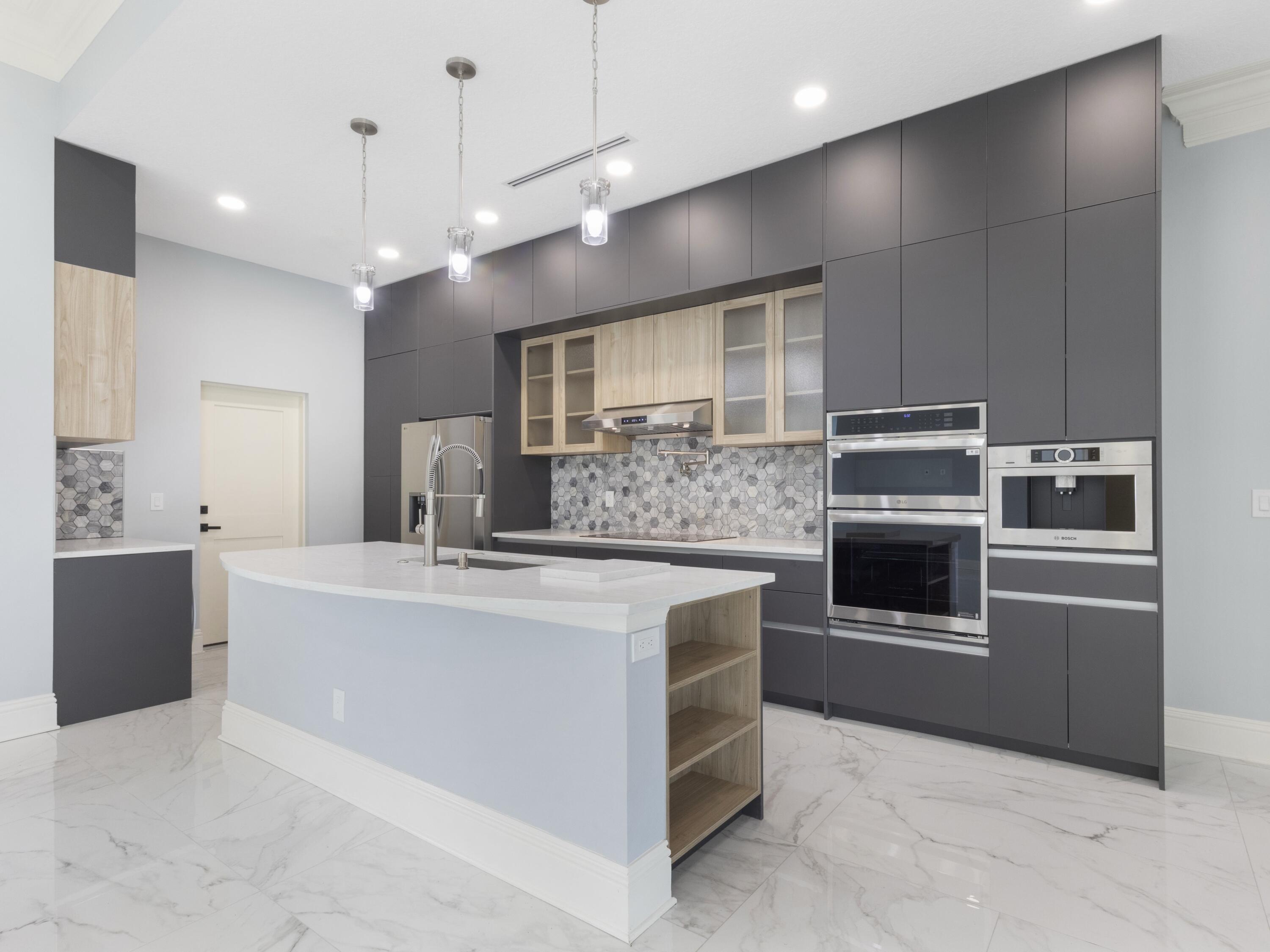 17436 71st Lane North Loxahatchee, FL 33470 - Photo 11 of 50 a large kitchen with a large counter top stainless steel appliances and cabinets