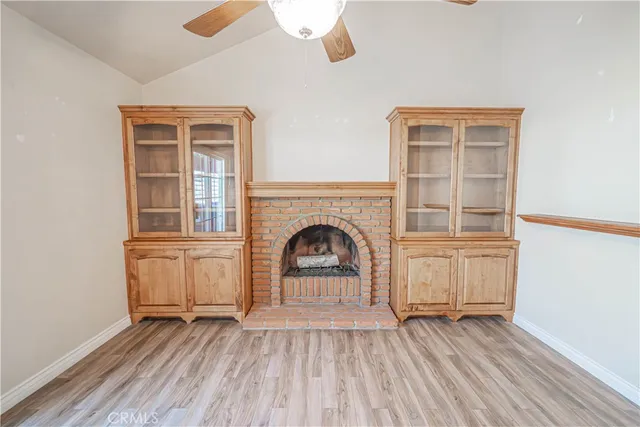 a view of a livingroom with wooden floor and kitchen space