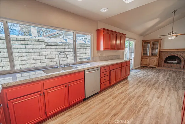 a large kitchen with stainless steel appliances wooden cabinets a stove and a large window