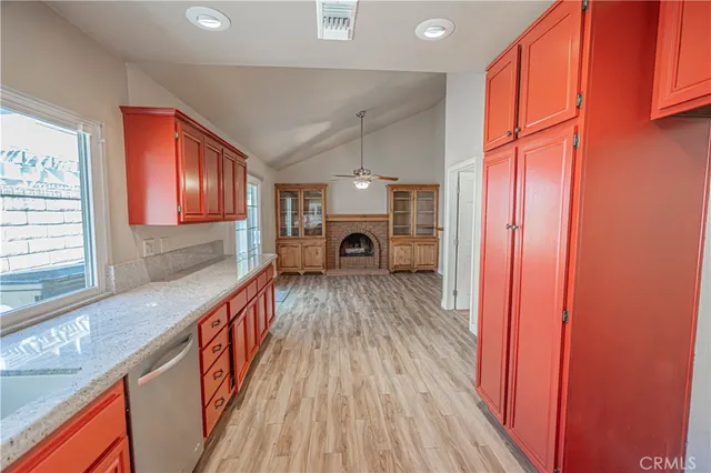 a view of a hallway with wooden floor staircase and a kitchen