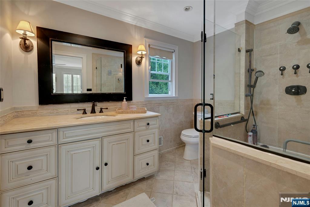 744 River Road Chatham, NJ 07928 - Photo 9 of 19 a bathroom with a double vanity sink a mirror and a bathtub