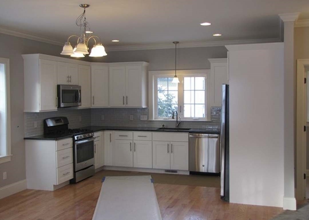 210 South Quinsigamond Avenue, Unit 1 Shrewsbury, MA 01545 - Photo 3 of 11 a kitchen with stainless steel appliances granite countertop a sink a stove a microwave a counter space and cabinets