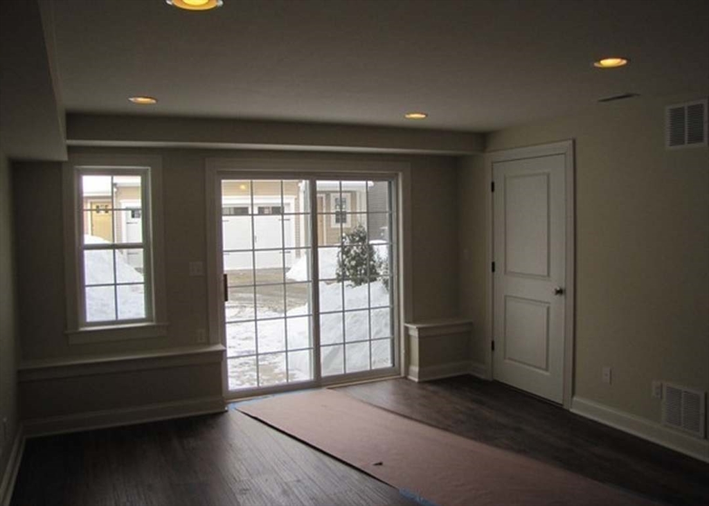 210 South Quinsigamond Avenue, Unit 1 Shrewsbury, MA 01545 - Photo 8 of 11 an empty room with wooden floor and windows