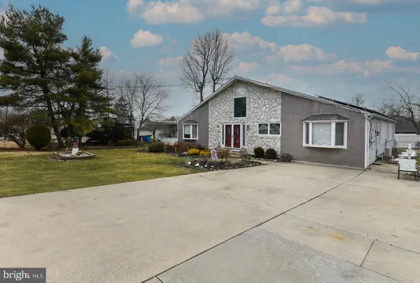 a front view of house with yard and trees around