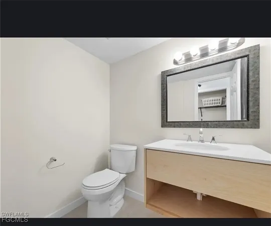 a bathroom with a toilet a sink and mirror