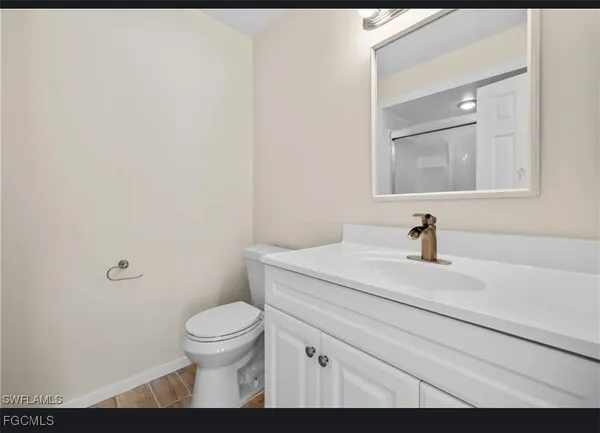 a bathroom with a granite countertop sink a toilet and a mirror