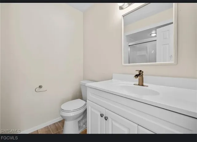 a bathroom with a granite countertop sink a toilet and a mirror