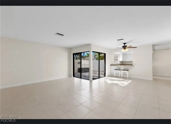 a view of an empty room with a kitchen