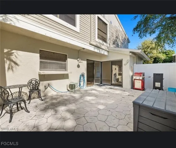 a view of a patio with a table and chairs and potted plants