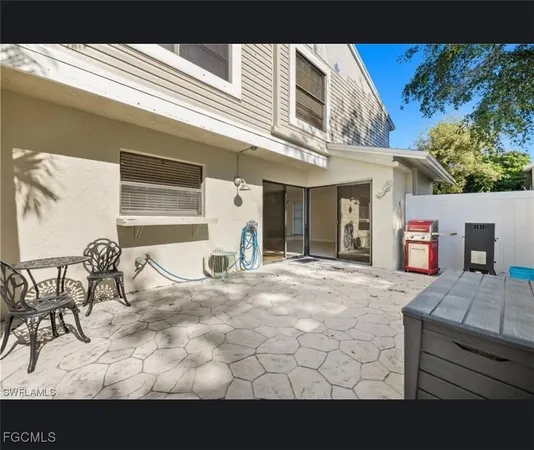 a view of a patio with a table and chairs and potted plants