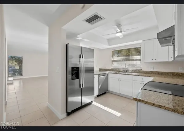a kitchen with a refrigerator sink and cabinets