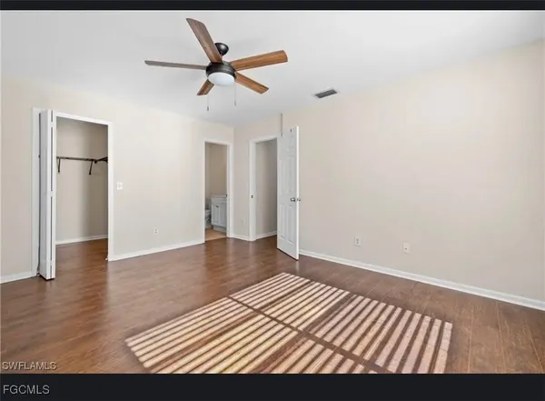 a view of a livingroom with wooden floor and a ceiling fan