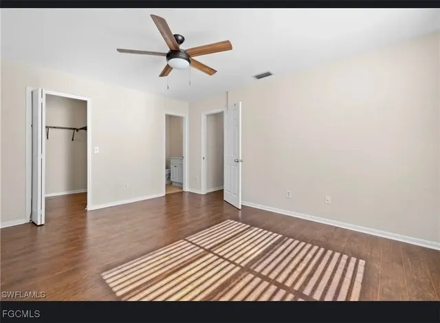 a view of a livingroom with wooden floor and a ceiling fan
