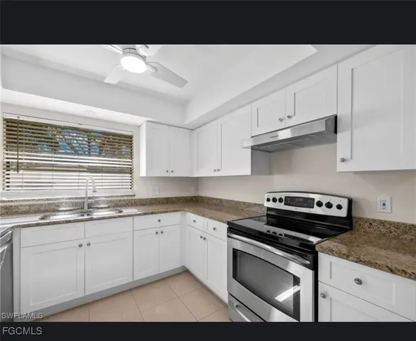a kitchen with stainless steel appliances granite countertop a sink stove and cabinets