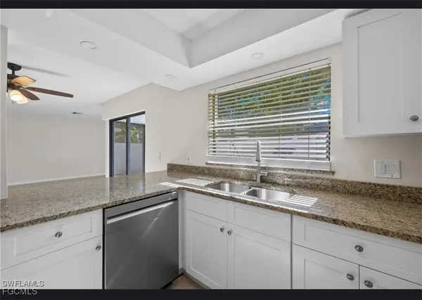 a kitchen with granite countertop cabinets sink and window