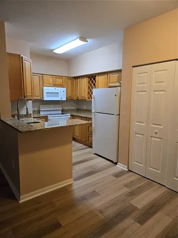 a kitchen with kitchen island a refrigerator sink and wooden floor