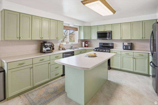 5108 South 2000th Street West Roy, UT 84067 - Photo 14 of 61 Kitchen with green cabinets, stainless steel appliances, light countertops, and a kitchen island