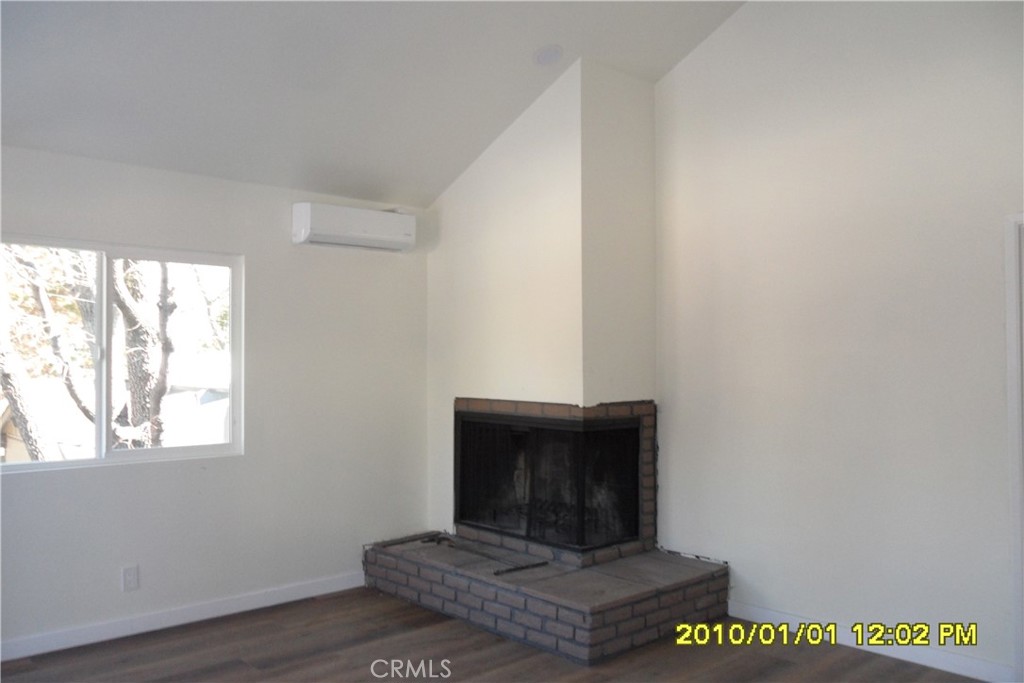 871 Maple Lane Sugarloaf, CA 92386 - Photo 11 of 17 a living room with a fireplace and a window